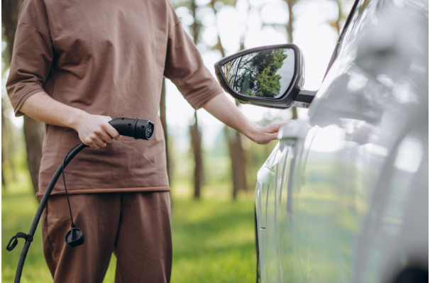 Man charging his electric car energy